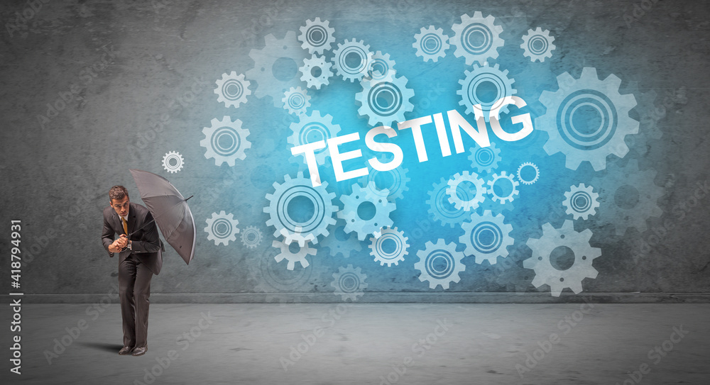 Fototapeta premium Businessman defending with umbrella from TESTING inscription, technology concept