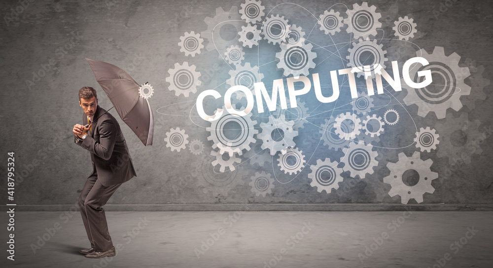 Businessman defending with umbrella from COMPUTING inscription, technology concept