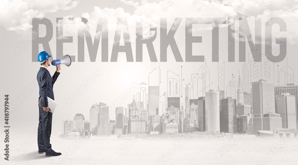 Young businessman with hard hat and REMARKETING inscription, new business opportunity concept Young businessman with hard hat and REMARKETING inscription, new business opportunity concept