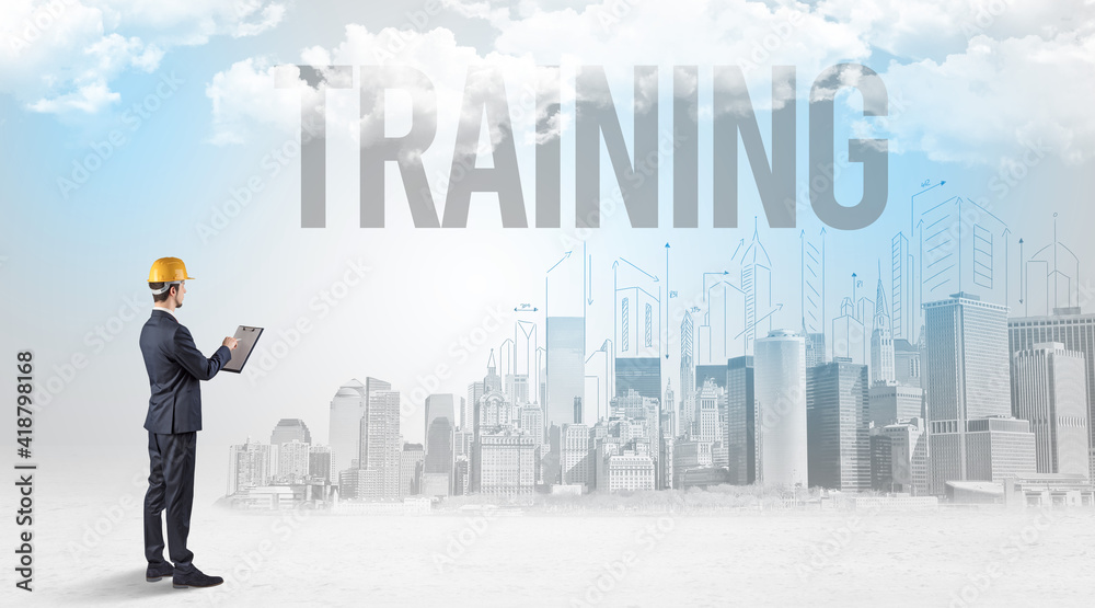 Young businessman with hard hat and TRAINING inscription, new business opportunity concept Young businessman with hard hat and TRAINING inscription, new business opportunity concept