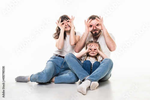 happy family mother father and child daughter sitting on the floor on white background