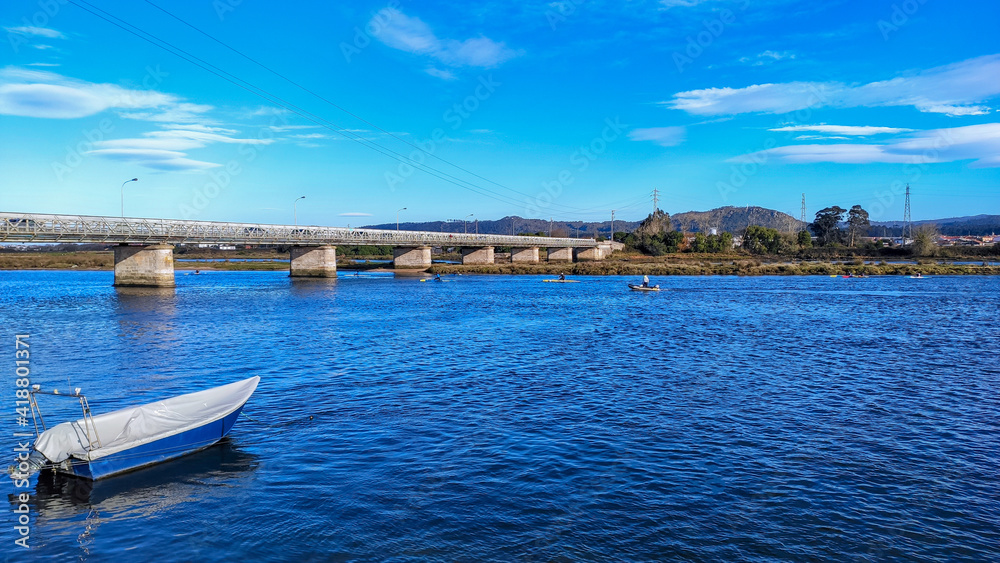 Fao, Esposende, Portugal -  January 10, 2021: The Fao metallic bridge, known as D. Luís Filipe Bridge. Canoeists on the Cavado River.