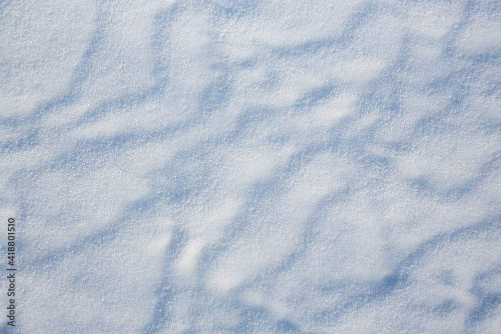 Beautiful winter background with snowy ground. Natural snow texture. Wind sculpted patterns on snow surface. Beautiful winter background with snowy ground. Natural snow texture. Wind sculpted patterns on snow surface.