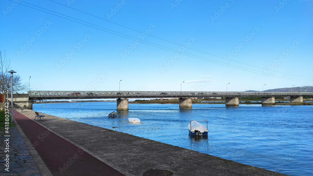 Fao, Esposende, Portugal -  January 10, 2021: The Fao metallic bridge, known as D. Luís Filipe Bridge. It is located at Fao in Braga District, crossing the Cávado River. The riverside promenade.