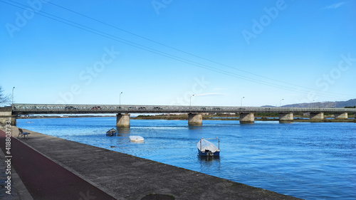 Fao, Esposende, Portugal -  January 10, 2021: The Fao metallic bridge, known as D. Luís Filipe Bridge. It is located at Fao in Braga District, crossing the Cávado River. The riverside promenade. photo