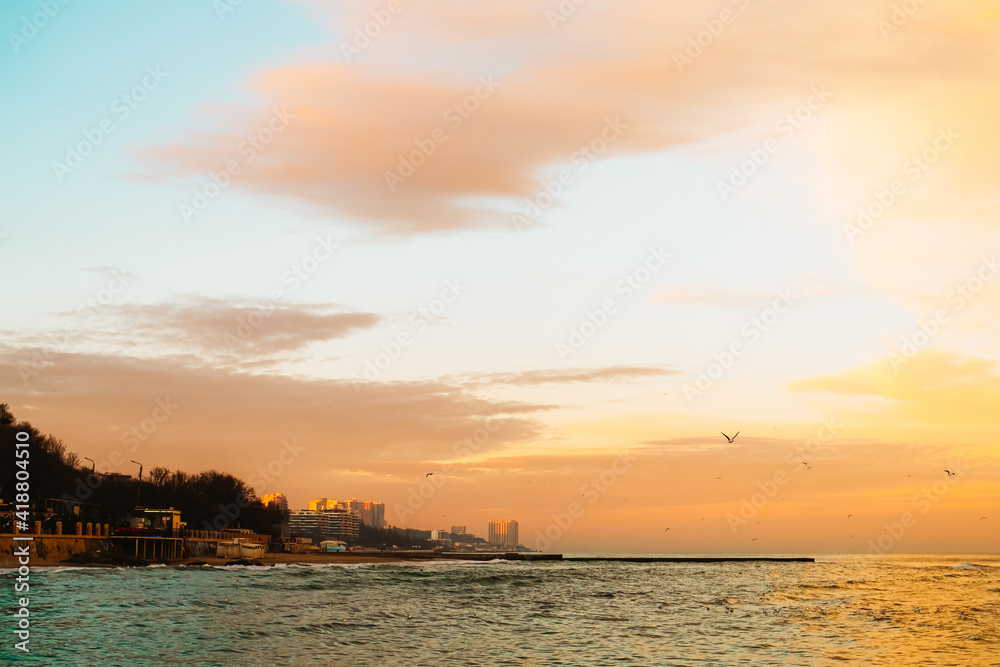 Photo of beautiful orange sunset on the sea, silhouette of lebanese city in sunrise on seashore, peaceful landscape, sun down on town on coast, warm weather, romantic vacation, holiday concept