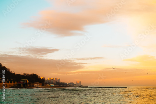 Photo of beautiful orange sunset on the sea, silhouette of lebanese city in sunrise on seashore, peaceful landscape, sun down on town on coast, warm weather, romantic vacation, holiday concept