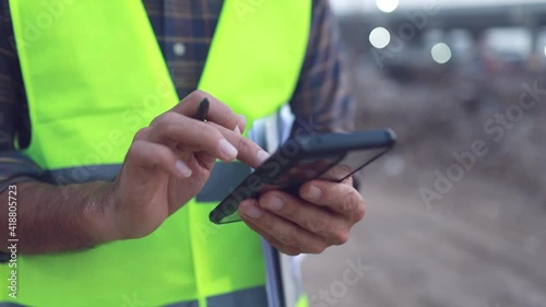 engineer working usung smartphone at the construction site photo