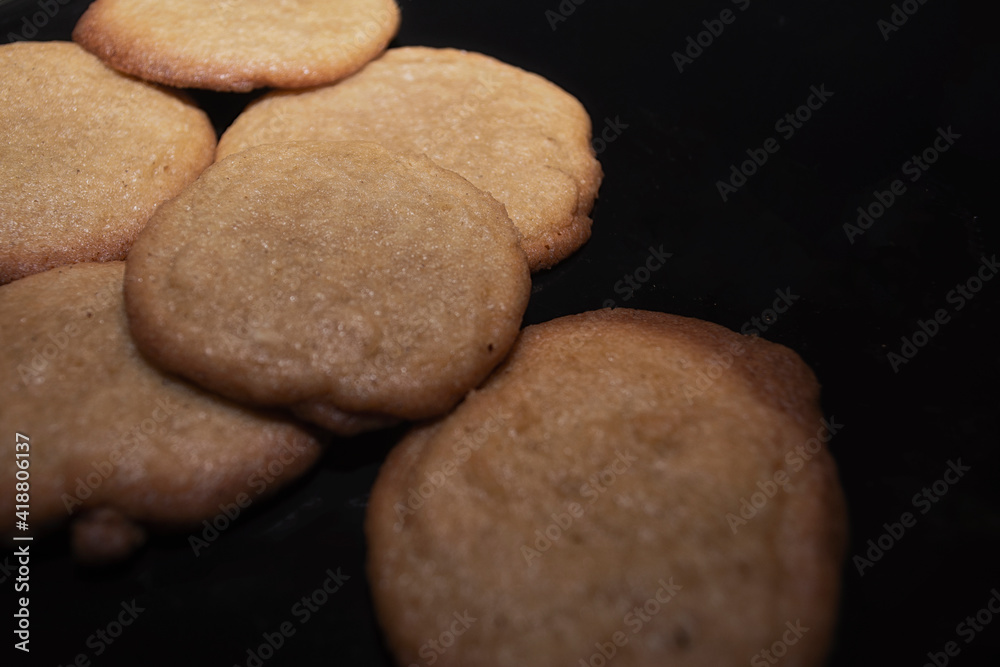 Obraz premium Fresh homemade cinnamon and sugar cookies on a black plate