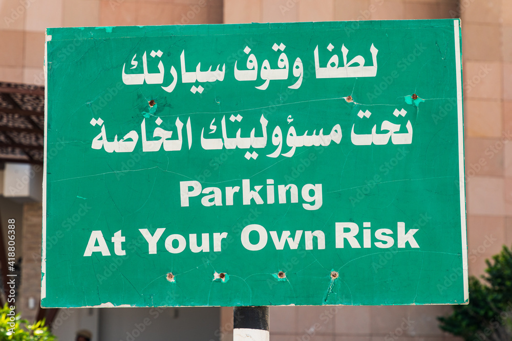 Parking sign in English and Arabic.