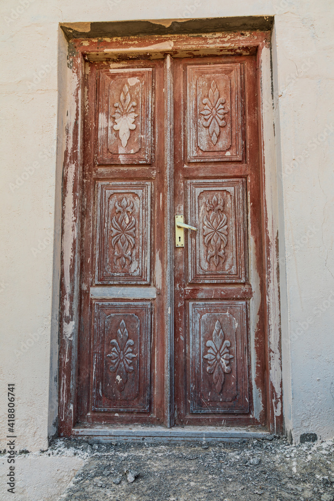 Old carved wooden door on a building in Oman.
