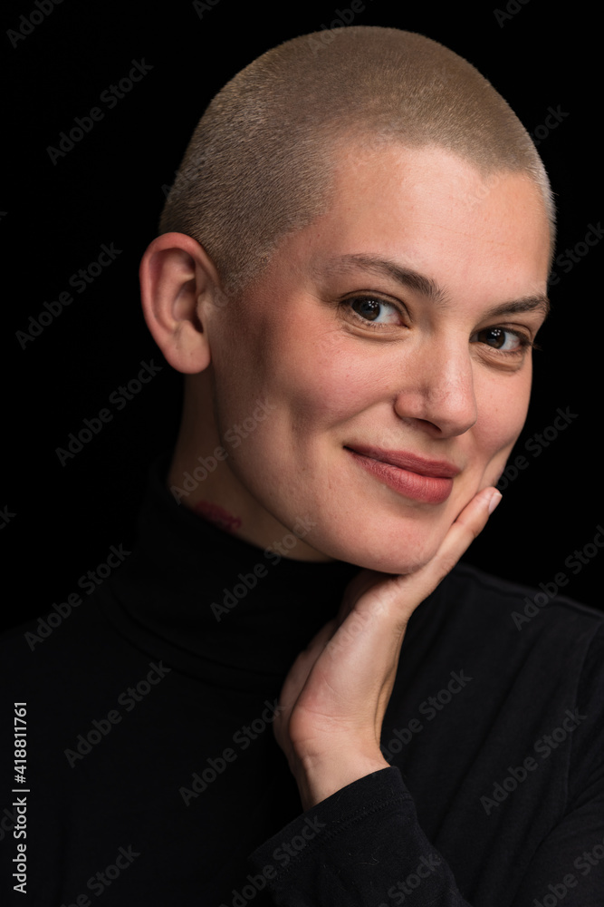 Obraz premium Young urban with short blonde hair poses before a black backdrop.