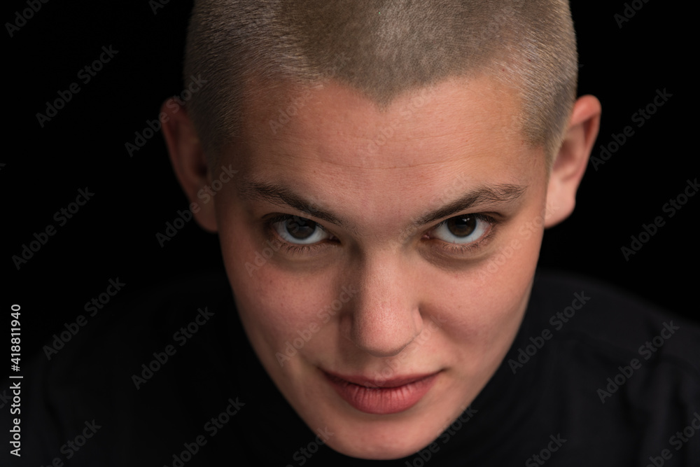 Obraz premium Young urban with short blonde hair poses before a black backdrop.