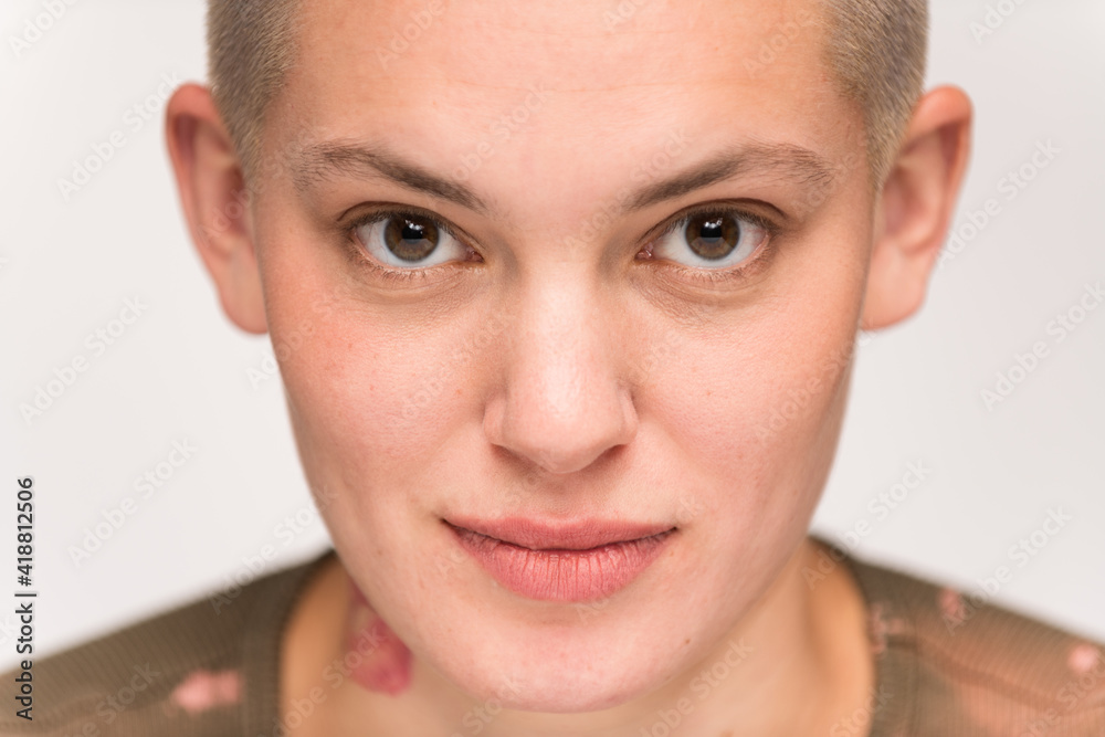 Young urban woman with short blond hair poses before a light colored background. Young urban woman with short blond hair poses before a light colored background.