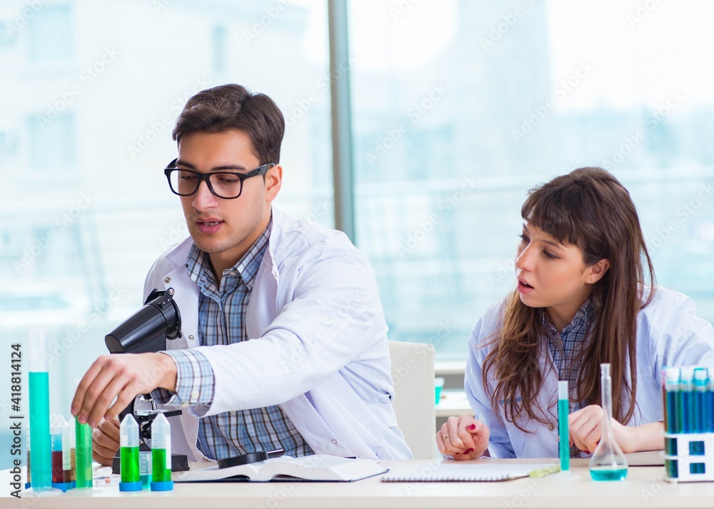 Fototapeta premium Two chemists working in lab experimenting