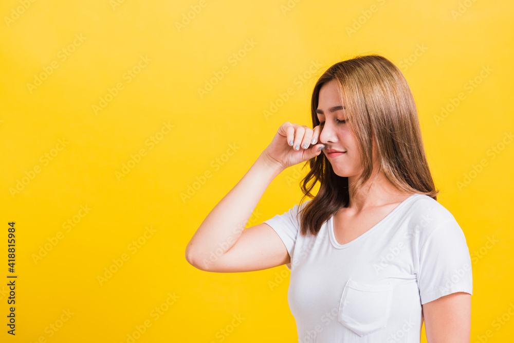 Asian Thai portrait beautiful cute young woman in depressed bad mood her cry wipe tears with fingers, studio shot isolated on yellow background with copy space Asian Thai portrait beautiful cute young woman in depressed bad mood her cry wipe tears with fingers, studio shot isolated on yellow background with copy space