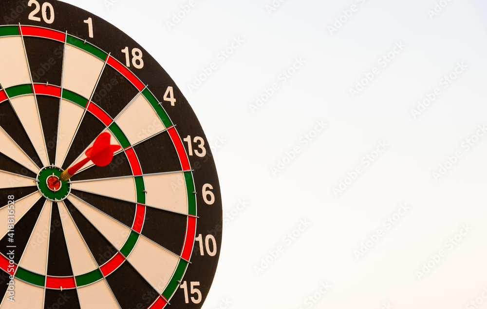 Dart arrow hit to center on bullseye(bull's-eye) of a dartboard is a target of purpose challenge business at sunset, expert strategy market target, objective financial and goal a concept Dart arrow hit to center on bullseye(bull's-eye) of a dartboard is a target of purpose challenge business at sunset, expert strategy market target, objective financial and goal a concept