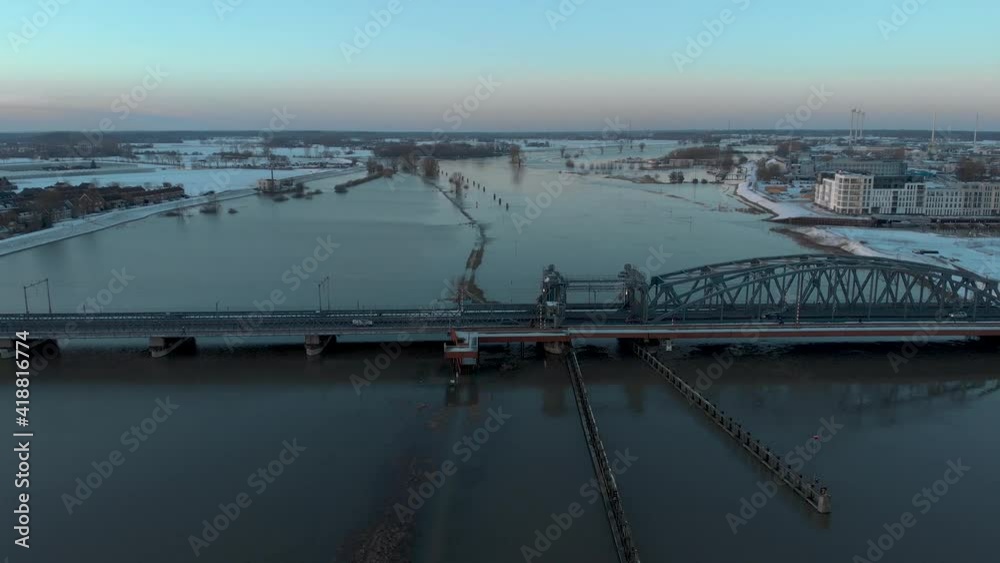 Sunset aerial backwards movement revealing the cityscape of Dutch Hanseatic medieval tower town Zutphen in The Netherlands with snow on the boulevard with draw bridge over river IJssel in foreground Sunset aerial backwards movement revealing the cityscape of Dutch Hanseatic medieval tower town Zutphen in The Netherlands with snow on the boulevard with draw bridge over river IJssel in foreground