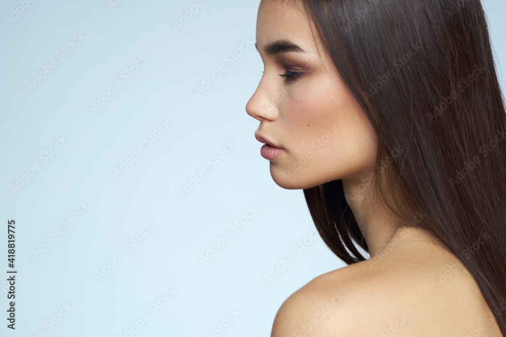 Woman with naked shoulders long hair clean skin cropped view blue background Woman with naked shoulders long hair clean skin cropped view blue background