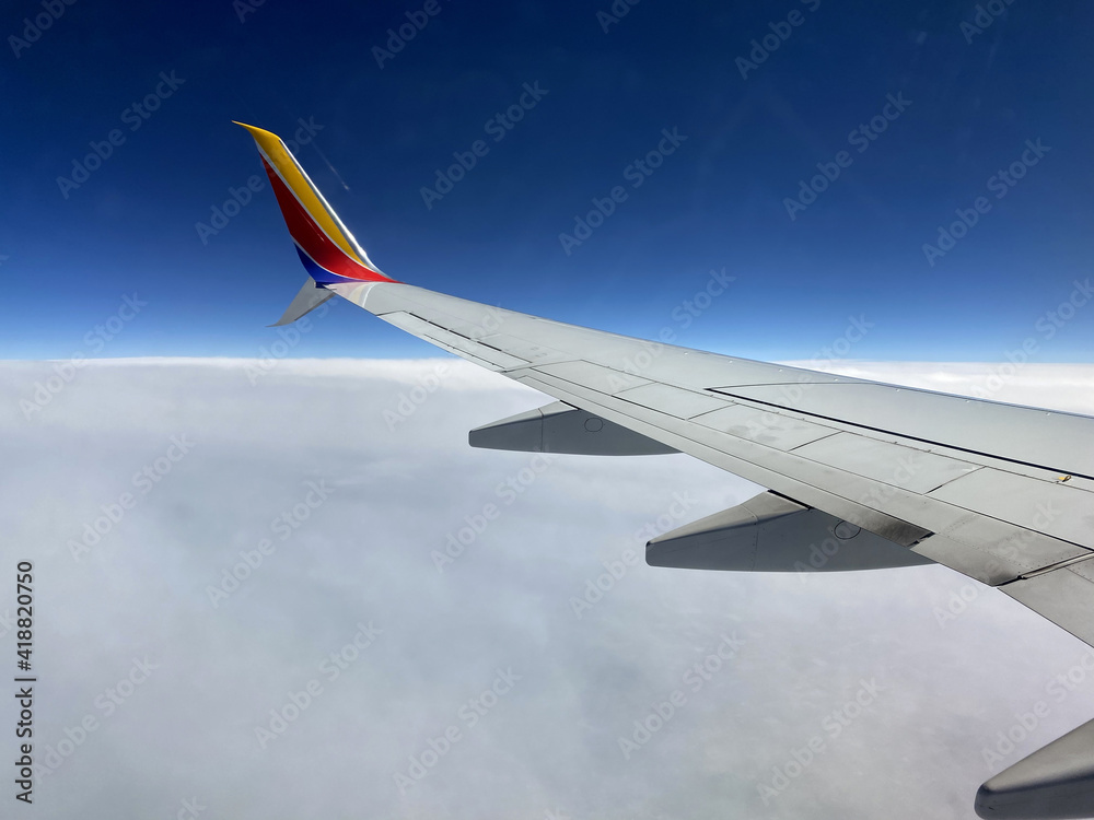 Fototapeta premium Airplane Wing Flying in the Clouds