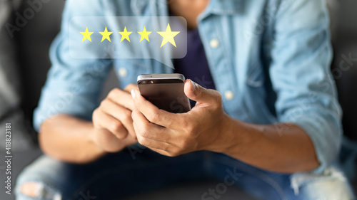 Foto Customer pressing on smartphone with five star icon for feedback review satisfac