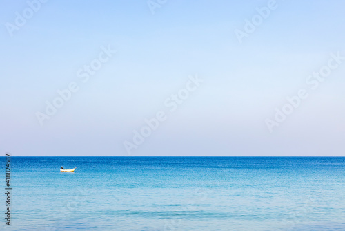 A photo of a morning sea landscape where the sea is reflected in the light and the blue water is refreshing. At Bang Tao Beach, Phuket Province, Thailand. Concept about travel, nature. No people © TripleP Studio