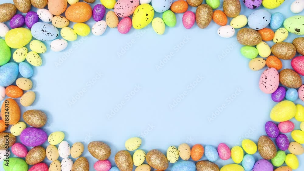 Colorful Easter eggs make copy space frame and move on pastel blue background. Stop motion Colorful Easter eggs make copy space frame and move on pastel blue background. Stop motion