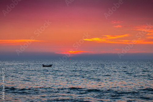 A photo of a sunset landscape where the sea is reflected in the orange light and the blue water is refreshing. At Bang Tao Beach  Phuket Province  Thailand. Concept about travel  nature. No people