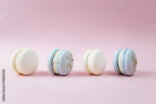 White and blue macaroons on the table, macaroons on pink background