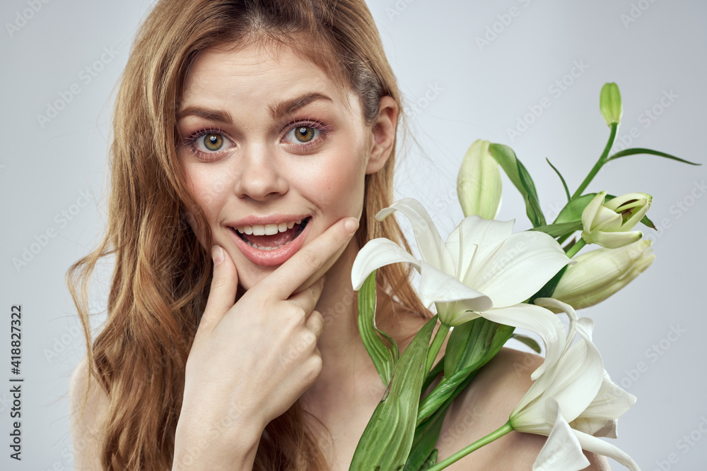 Emotional woman with flowers spring model naked shoulders clear skin Emotional woman with flowers spring model naked shoulders clear skin