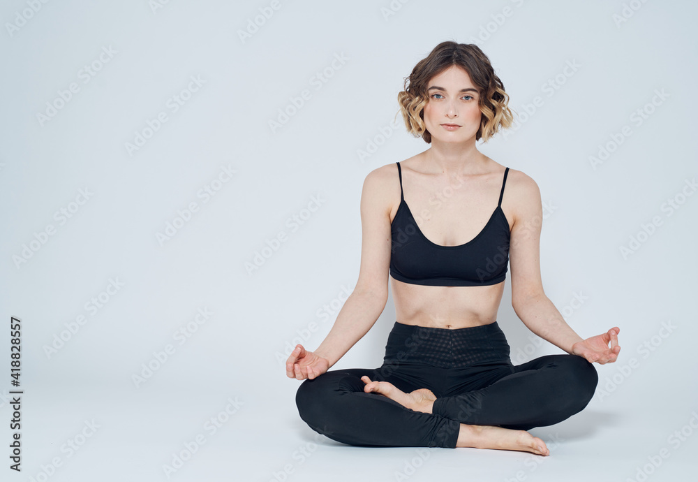 Woman with crossed legs meditate while sitting on the floor of yoga asana