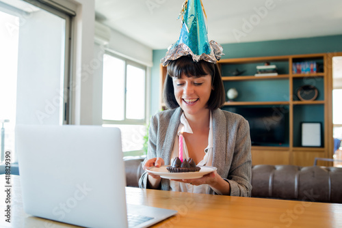 Woman celebrating her birthday online from home.