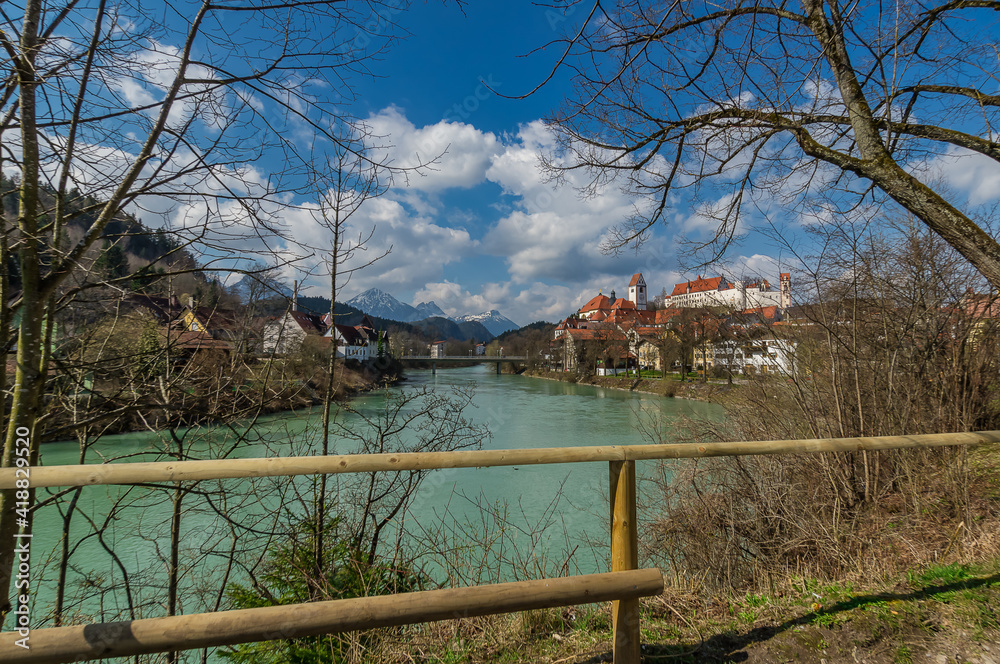 View over the river Lech in the city Fuessen and the alp mountains in the background at an wonderful day with a blue sky at springtime. View over the river Lech in the city Fuessen and the alp mountains in the background at an wonderful day with a blue sky at springtime.