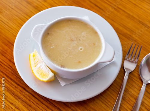 Homemade turkish soup Tavuk Suyu corbasi in a white ceramic soup plate