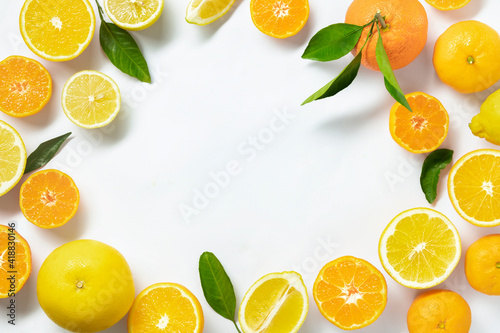 Frame of summer tropical fruits with leaves, grapefruit, orange, tangerine, lemon on white background. Flat lay, top view. Citrus background