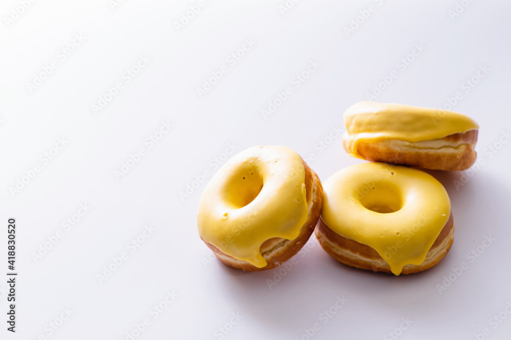 three donuts with banana filling lie on a white background, delicious breakfast, bright mood, space for text three donuts with banana filling lie on a white background, delicious breakfast, bright mood, space for text