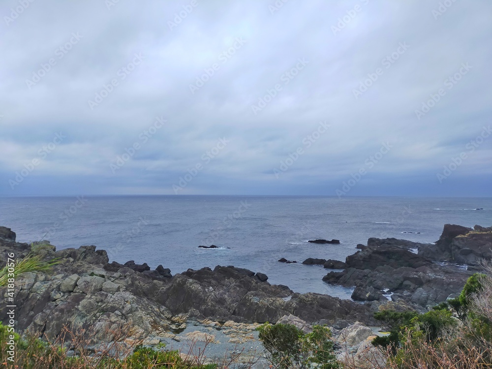 曇り空を背景にした本州最南端串本町潮岬の海の水平線の風景（コピースペースあり）