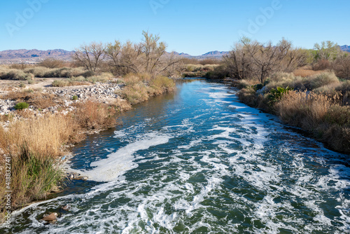 Las Vegas Wash flowing swiftly towards Lake Mead below a weir at Clark County Wetland Park