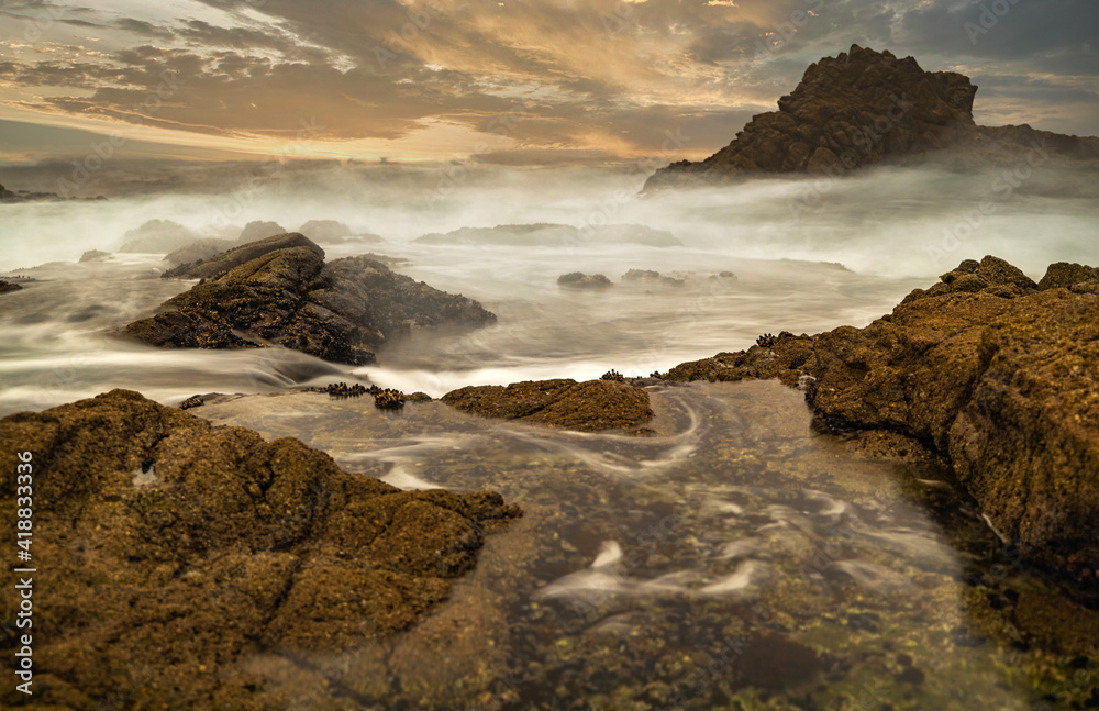 Fototapeta premium Long exposure water, beautiful seascape, ocean views, rocky coastline, sunlight on the horizon. Composition of nature. Sunset scenery background. Cloudy sky. California coast.