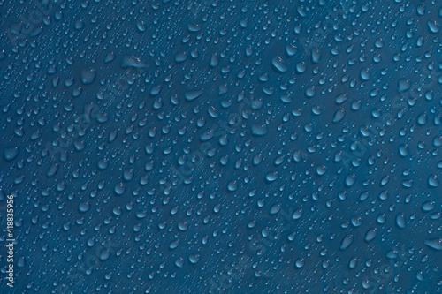Drops abstract texture. Wet water on blue glass background. Bubble pattern.