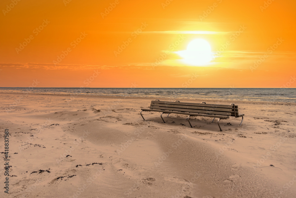 Empty Bench on a Windswept Baltic Seacoast Beach on a Winter Day at Sunset