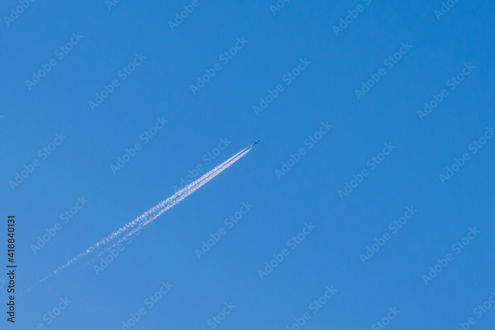 Small Airplane and trail across the blue sky Small Airplane and trail across the blue sky