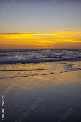 Yellow sunset on the beach. Seascape for background. Colorful sky. Beautiful water reflection. Sunlight on horizon line. Nature and environment concept. Copy space. Sunset in Bali.
