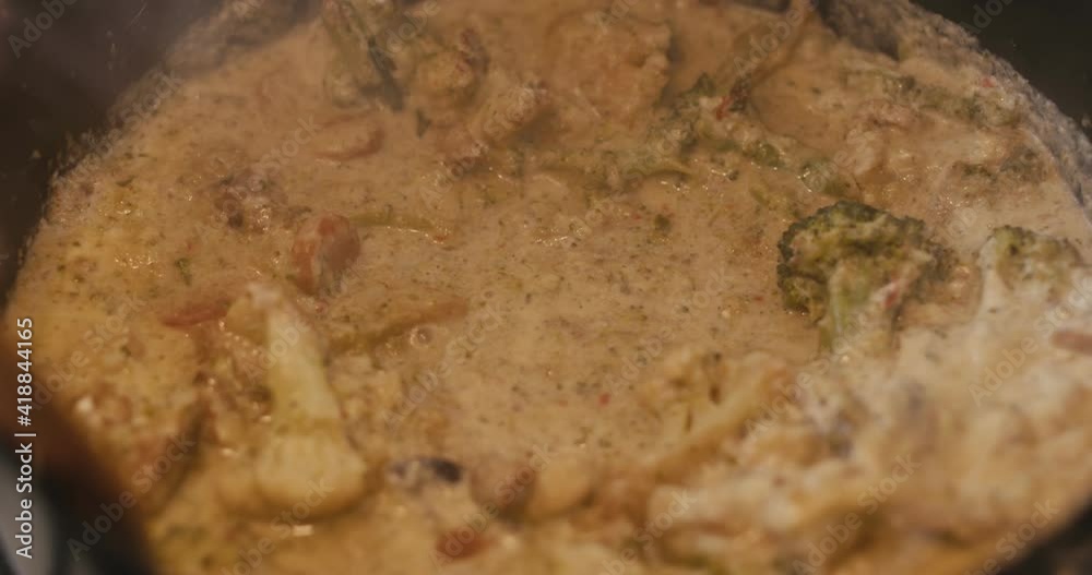 Woman hand stir Thai vegetable curry use wooden fork cooking close up Woman hand stir Thai vegetable curry use wooden fork cooking close up