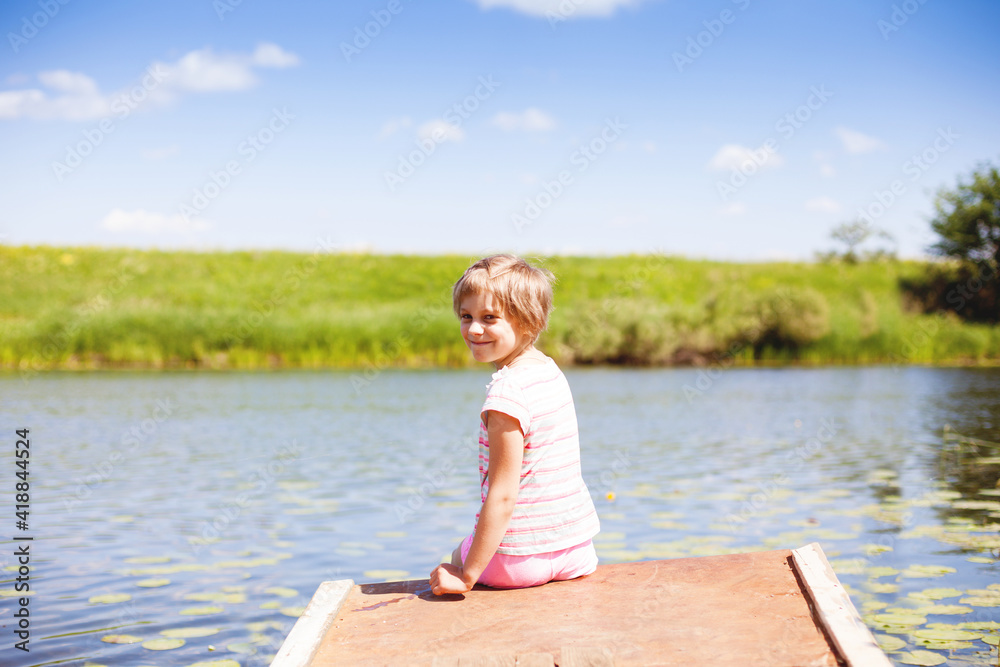 7-year-old girl sitting on  bank by   river
