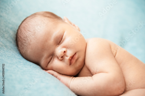 Cute newborn baby on blue background. Copy space and top view
