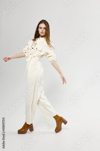 fashionable woman in white jumpsuit on a light background stylish clothes emotions model