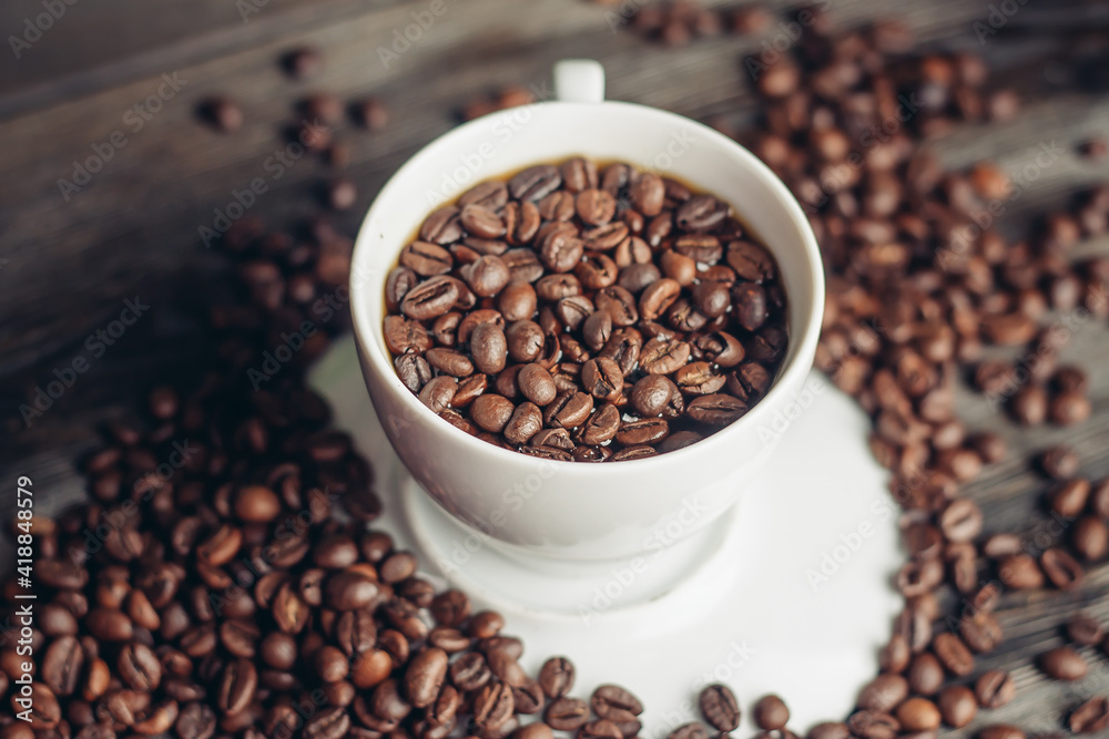 Fototapeta premium Hot drink in a saucer and sprinkled grain on a wooden table top view