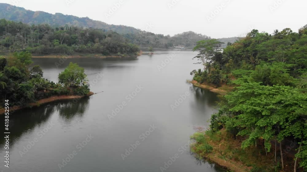 Aerial drone shot of a tranquil lake in tropical forest in Borneo Kalimantan Indonesia. Rainforest and serene water landscape