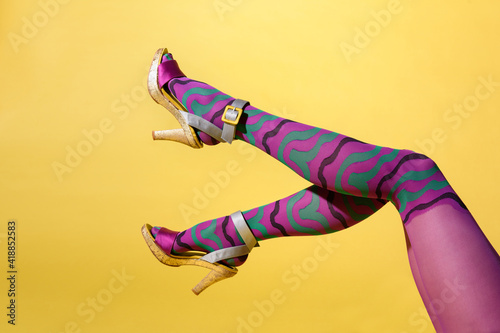 Waving sexy female legs in multicolored purple collant photo